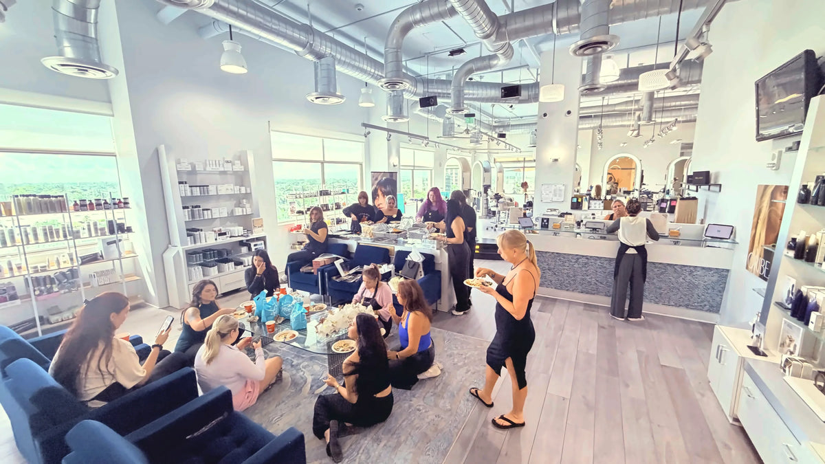 Salon Sora team gathered in the lounge and reception, with 7th-floor windows over Boca Raton