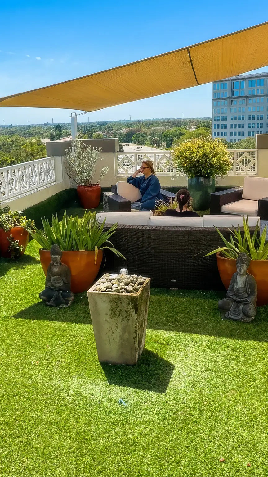 Salon Sora's 7th-floor rooftop garden in Boca Raton: turf lawn, Buddha statues, potted plants and skyline views (AI-enhanced photo)